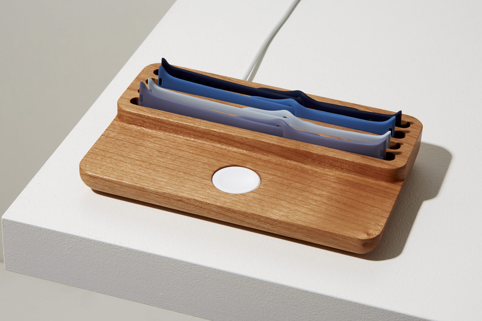 Anden Watch Valet in oak with spare straps and the charger opening visible