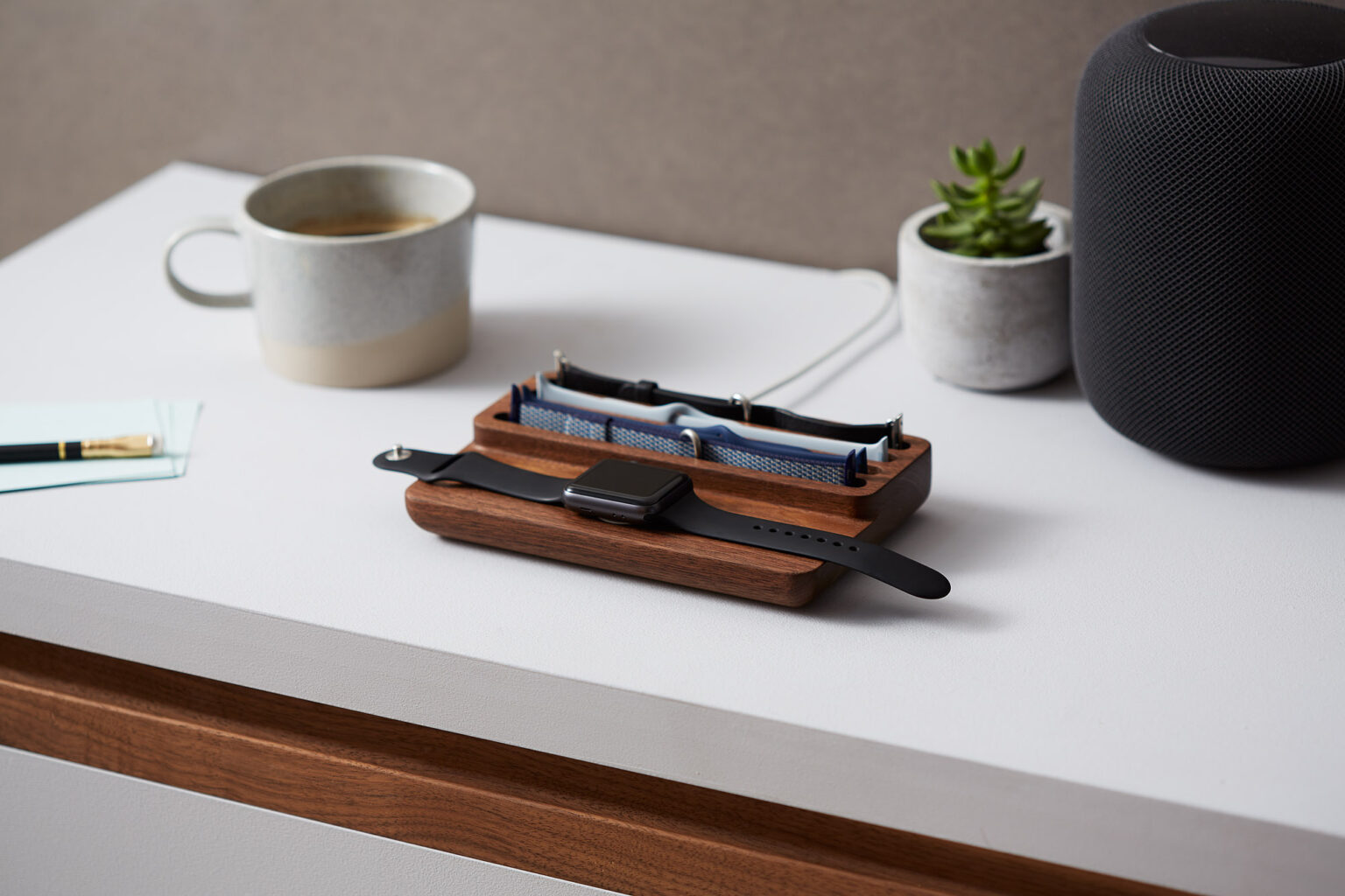 Anden Watch Valet on a desk with an Apple Watch, beside a mug and a plant