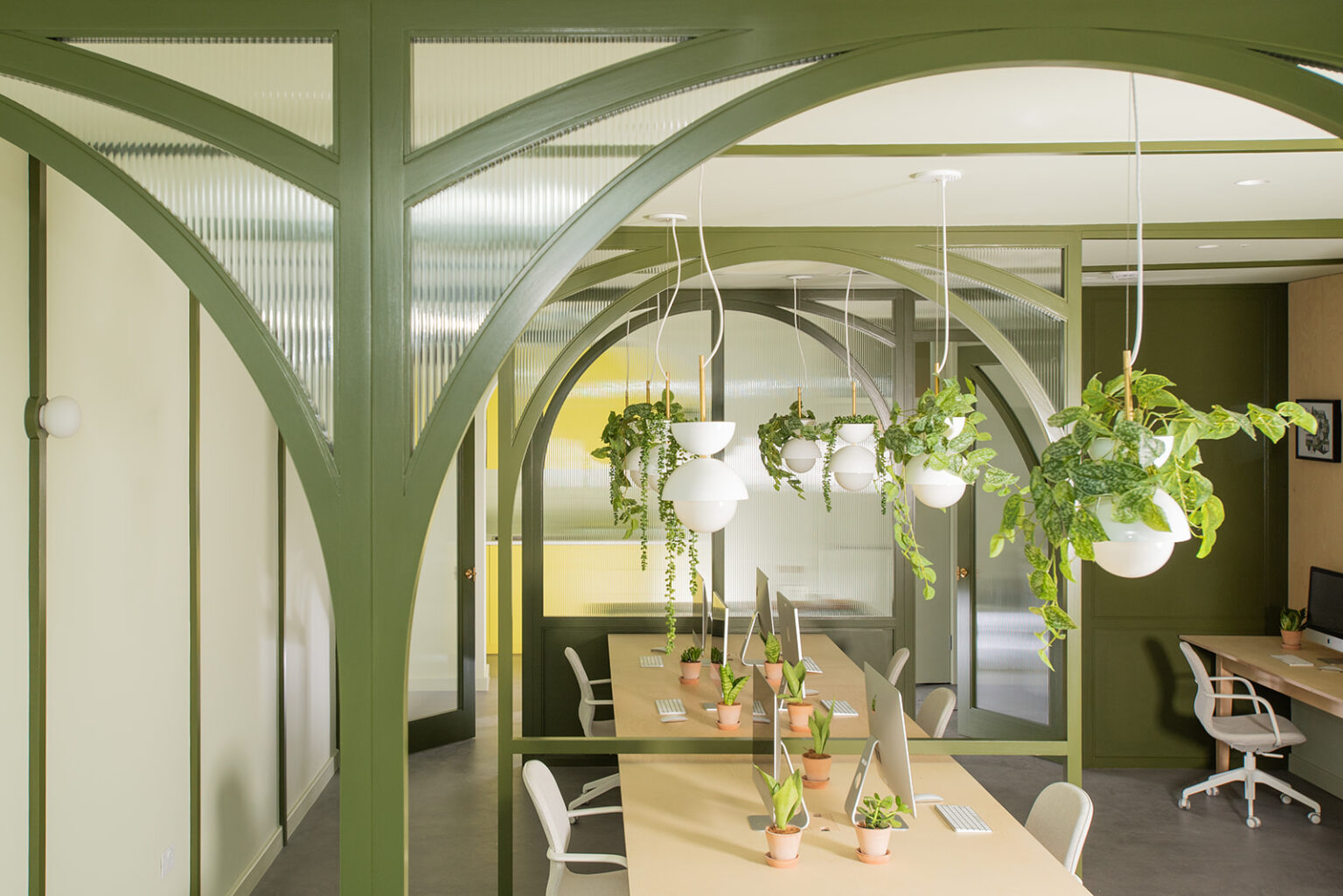 Stow Brothers South Woodford office with timber bench office desks and green arched timber partitions