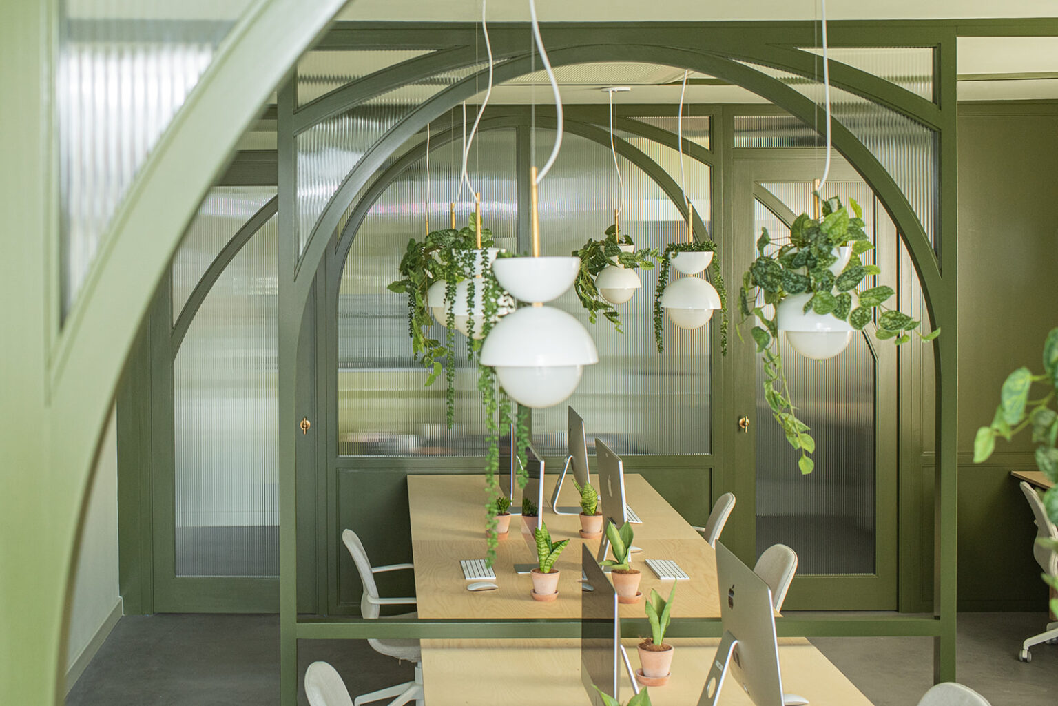 Stow Brothers South Woodford office with timber bench office desks and green arched timber partitions